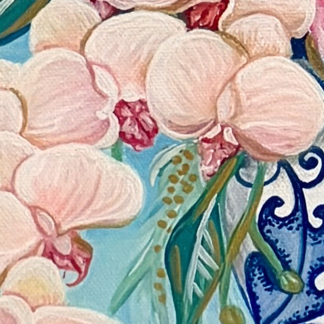 Close-up of pink orchids with a decorative blue and white background