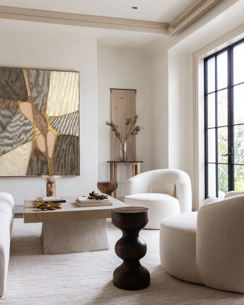 Modern living room with neutral tones, abstract art, and decorative elements.