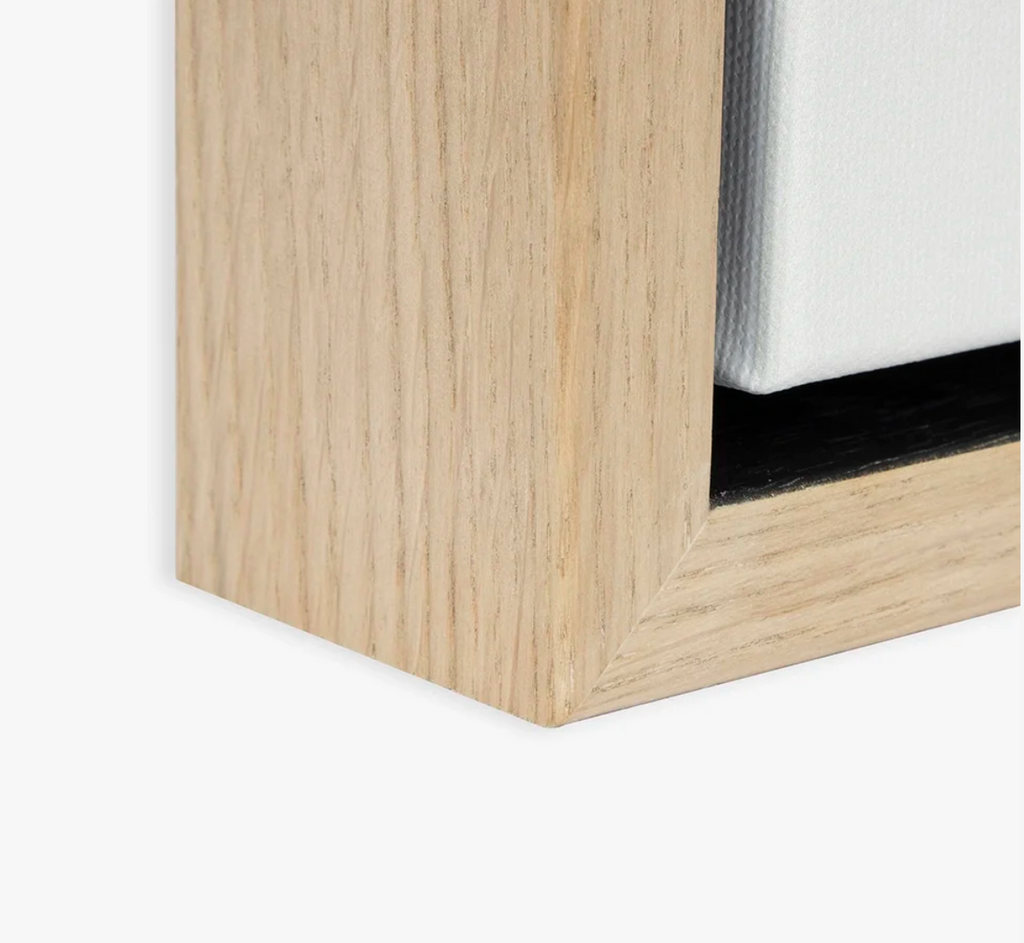 Close-up of a wooden art frame corner with a white canvas.