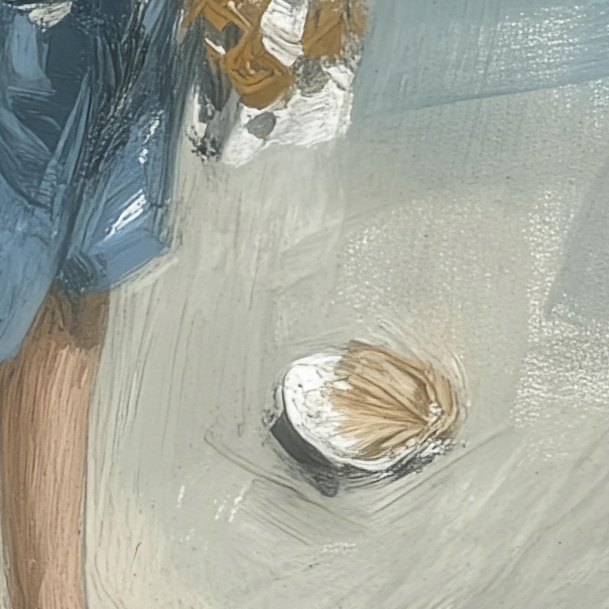 Close-up of a shell on a sandy surface with a blurred background
