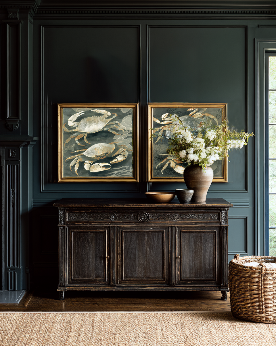 Dark wood sideboard with framed crab art and a vase of flowers against a dark wall.