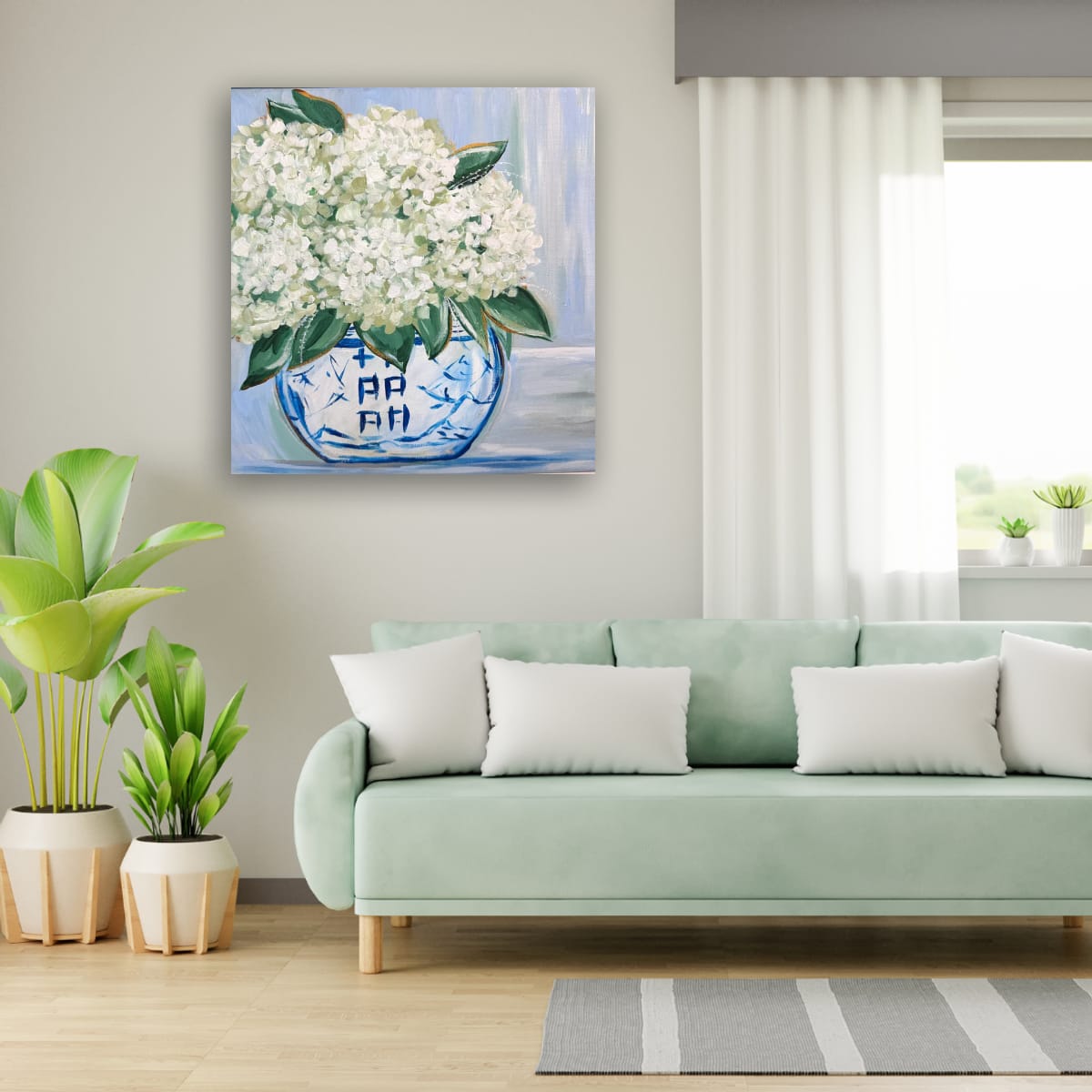 Living room with a light green sofa, potted plants, and a painting of white flowers in a blue vase on the wall.