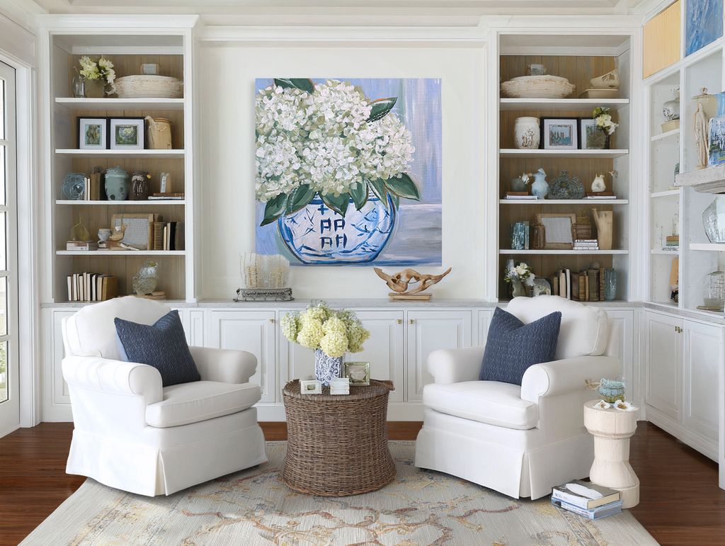 Living room with white armchairs, a coffee table, and decorative items.